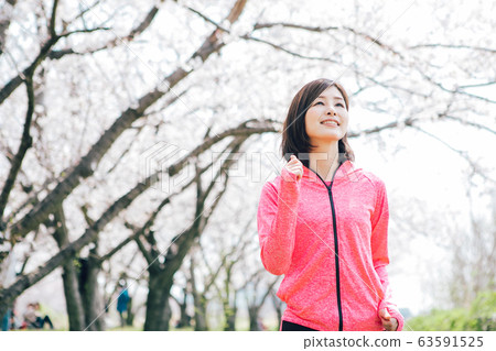 A woman jogging under the cherry tree 63591525
