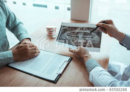 Dentist hand holding pen pointing x-ray picture 63592288