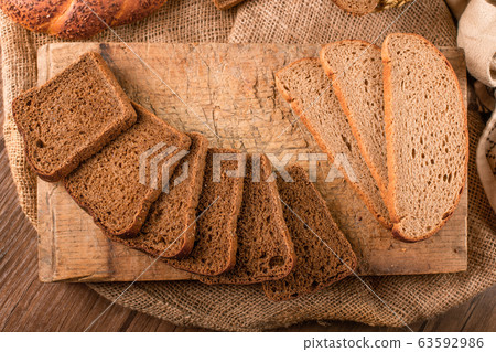 Slices of dark and white bread on the kitchen board Slices of dark and white bread on the kitchen board 63592986