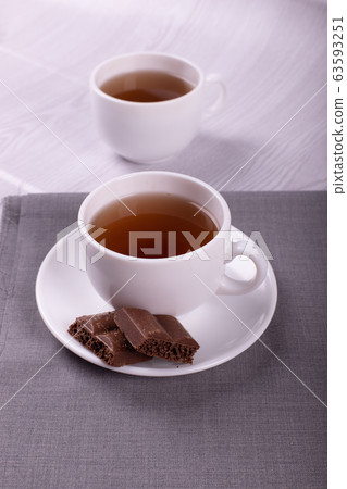 Cup of tea and chocolate with light background 63593251