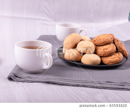 Two cups of black tea with sweeties Two cups of black tea with sweeties 63593820