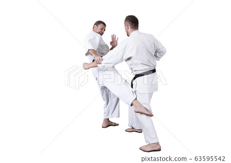 Adult athlete performs formal goju-ryu exercises. 63595542
