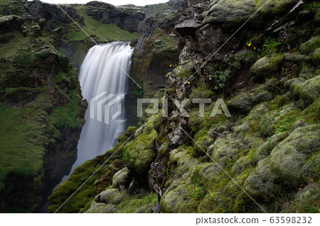Beautiful smooth waterfall in Iceland during evening dusk Beautiful smooth waterfall in Iceland during evening dusk 63598232