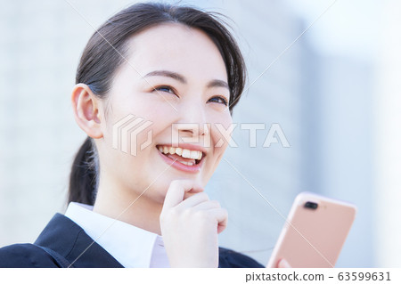 A young business woman using a smartphone on the roof A young business woman using a smartphone on the roof 63599631