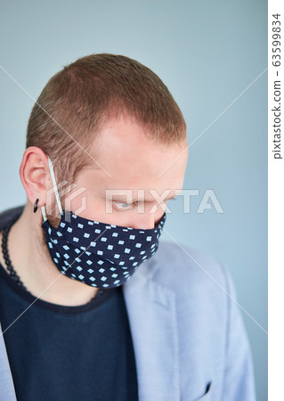 Portrait of man wearing black mask at grey background. Portrait of man wearing black mask at grey background. 63599834