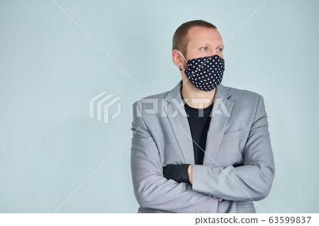Portrait of man wearing black mask at grey background. Portrait of man wearing black mask at grey background. 63599837