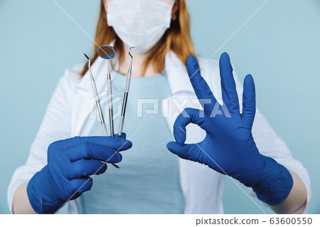 Dentist appointment, dentistry instruments and dental hygienist checkup concept with teeth model dentures and stomatology instruments on dark grey. Regular checkups are essential to oral health Dentist appointment, dentistry instruments and dental hygienist checkup concept with teeth model dentures and stomatology instruments on dark grey. Regular checkups are essential to oral health 63600550