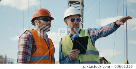 Engineer and technician discussing on rooftop 63601336