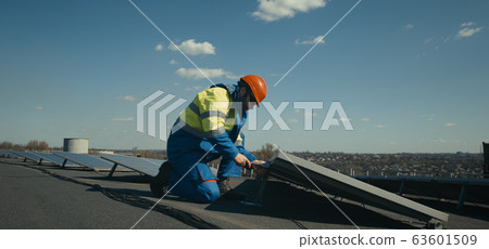 Technician installing solar panel and looking at camera 63601509