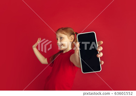 Caucasian little girl portrait isolated on red studio background, emotions concept Caucasian little girl portrait isolated on red studio background, emotions concept 63601552