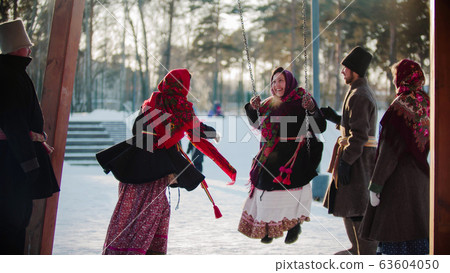 Russian folklore - Russian woman swinging and everyone is laughing on a sunny day Russian folklore - Russian woman swinging and everyone is laughing on a sunny day 63604050