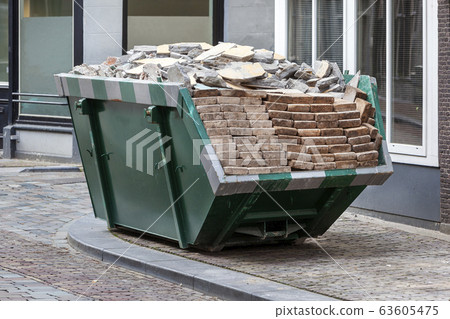 Neat industrial skip full loaded with bricks and Neat industrial skip full loaded with bricks and 63605475