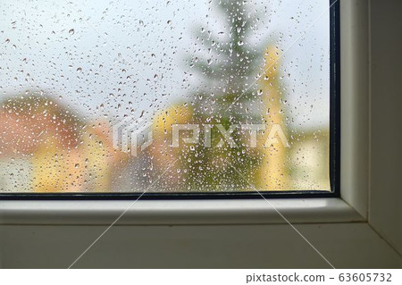 Blurred view on a rainy day through the window. Raindrops on the glass window. 63605732