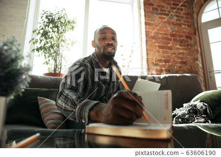 African-american man, freelancer during the work in home office while quarantine African-american man, freelancer during the work in home office while quarantine 63606190