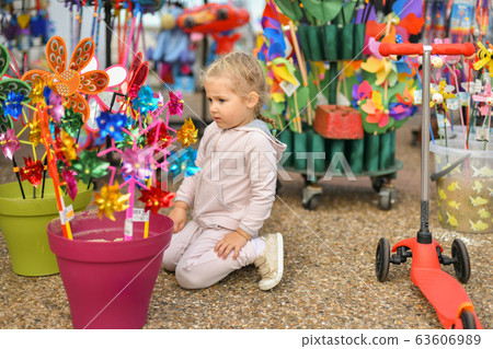 Girl looks at the windmills in the store Girl looks at the windmills in the store 63606989
