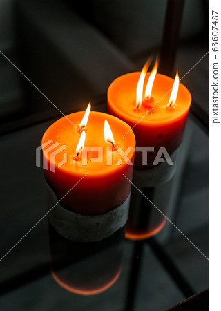 red candle on a concrete base 63607487