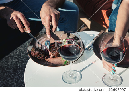 man eating meat with vegetables. Outdoors. Natural 63608097