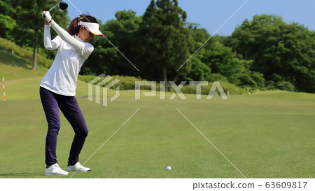 Woman hitting the tee shot 63609817