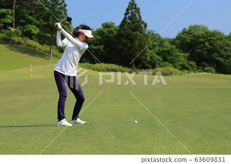 Woman hitting the tee shot 63609831