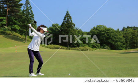 Woman hitting the tee shot 63609842