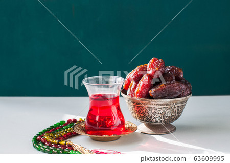 Medjoul kurma in a vintage bowl and glass of 63609995