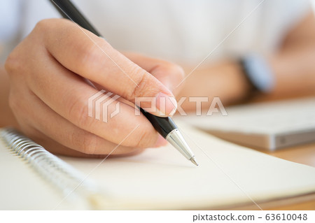 Close shot of businesswoman hands holding a pen Close shot of businesswoman hands holding a pen 63610048