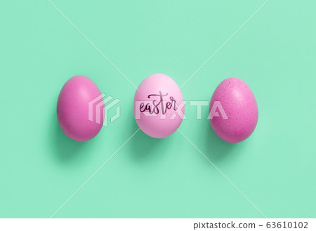 Pink eggs with inscription EASTER over light green 63610102