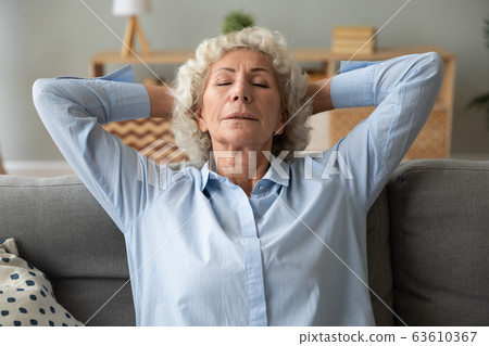 Senior woman relax sleep on cozy sofa at home Senior woman relax sleep on cozy sofa at home 63610367