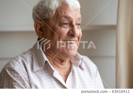 Head shot happy older man with healthy smile dreaming 63610411