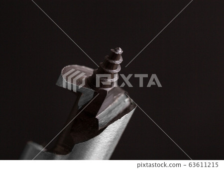 Spiral drill. Spiral steel drill on a dark Spiral drill. Spiral steel drill on a dark 63611215