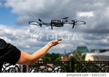Drone landing on hand. Drone and photographer man hands.drone copter flying with digital camera 63611301