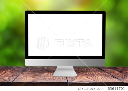 Mockup computer screen on wooden table against a blurred background. 63611701