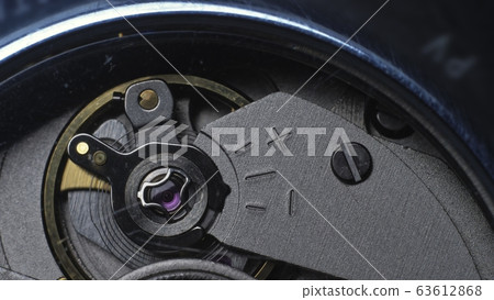 Watch mechanism macro loop. Old vintage clock mechanism working, closeup shot with soft focus. Close up of a internal clock mechanism. Watch mechanism macro loop. Old vintage clock mechanism working, closeup shot with soft focus. Close up of a internal clock mechanism. 63612868