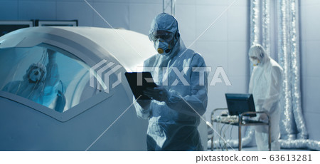 Engineer turning to camera in clean room Engineer turning to camera in clean room 63613281