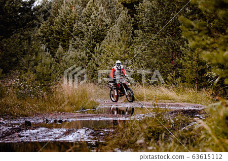 enduro racer riding a dirty trail 63615112