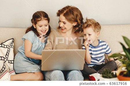 Happy mother with kids using laptop at home. 63617916