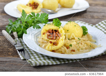 Handmade potato dumplings stuffed with greaves served on warm cabbage salad, an Austrian and Bavarian specialty Handmade potato dumplings stuffed with greaves served on warm cabbage salad, an Austrian and Bavarian specialty 63617964