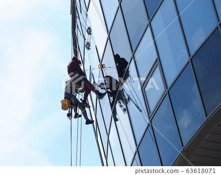 People professionally work at height wash windows 63618071