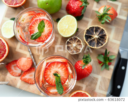 Glass poured cocktail with slices strawberries 63618072