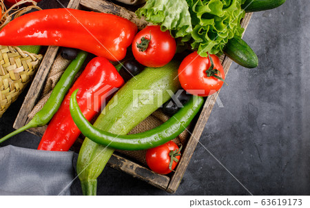Chili peppers and tomatoes in a wooden tray. Chili peppers and tomatoes in a wooden tray. 63619173