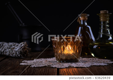 Esoteric still life with burning candle, green 63620439