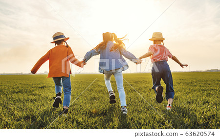 Anonymous happy children running backin field 63620574