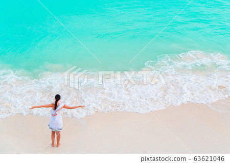 Young woman enjoying the sun sunbathing by perfect turquoise ocean 63621046