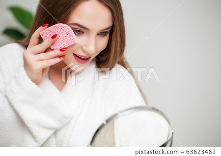 Pretty girl wipes the face after taking a shower sponge Pretty girl wipes the face after taking a shower sponge 63623461