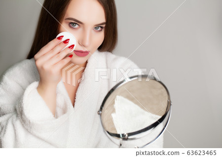 Pretty girl wipes the face after taking a shower sponge 63623465