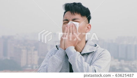 man has allergy and sneeze 63625487