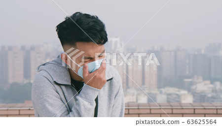 man coughs and wears mask 63625564