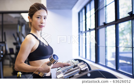 Woman choosing dumbbells 63626052