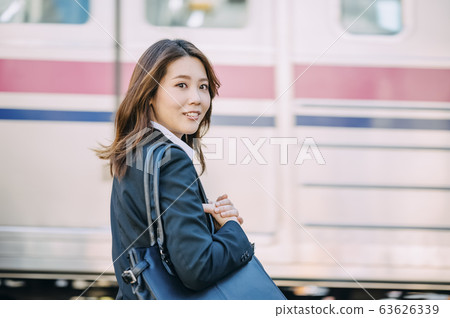 Business woman waiting for a railroad crossing 63626339