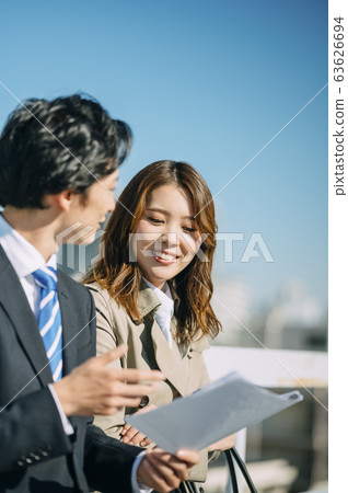 Businessman and businesswoman on the rooftop Businessman and businesswoman on the rooftop 63626694